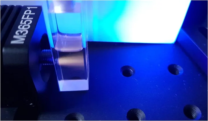 Luminescent sample in a cuvette under optical excitation